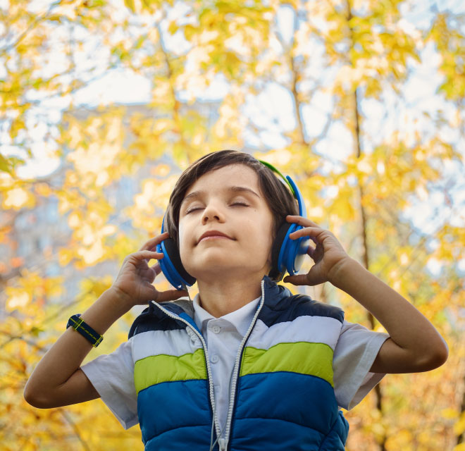 Boy enjoying music from his headphones, Audiologist, Balance and Hearing in Montana